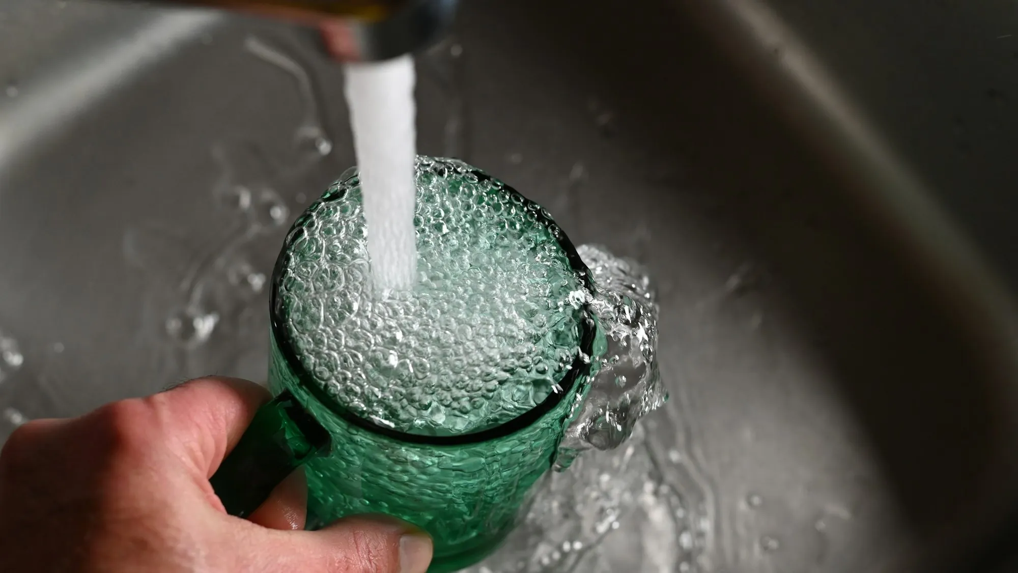 Glass being filled with filtered water at a kitchen sink
