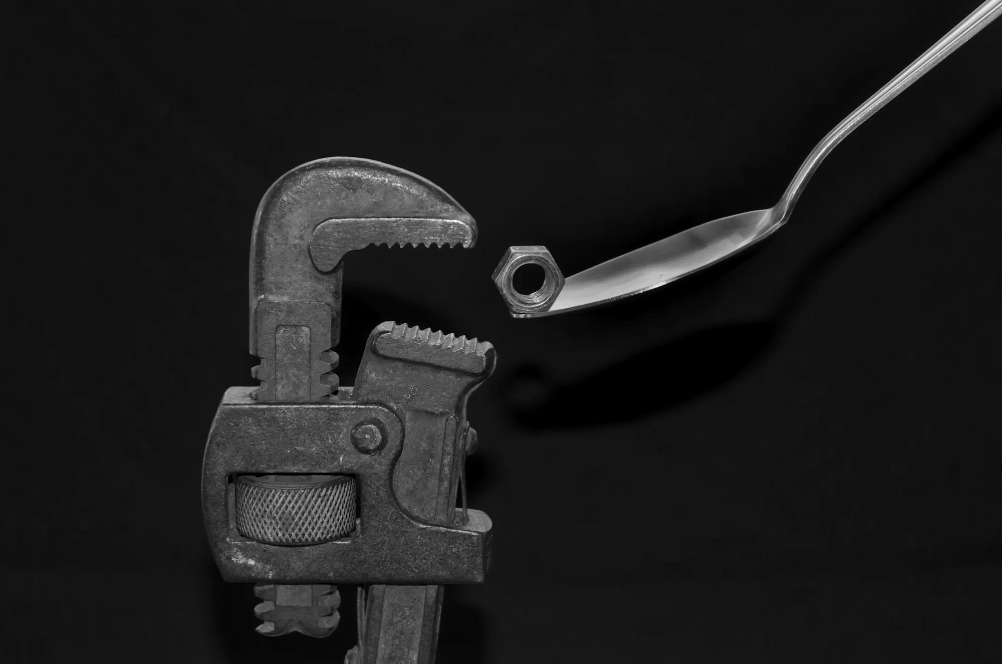 Plumbing wrench resting on a dark surface
