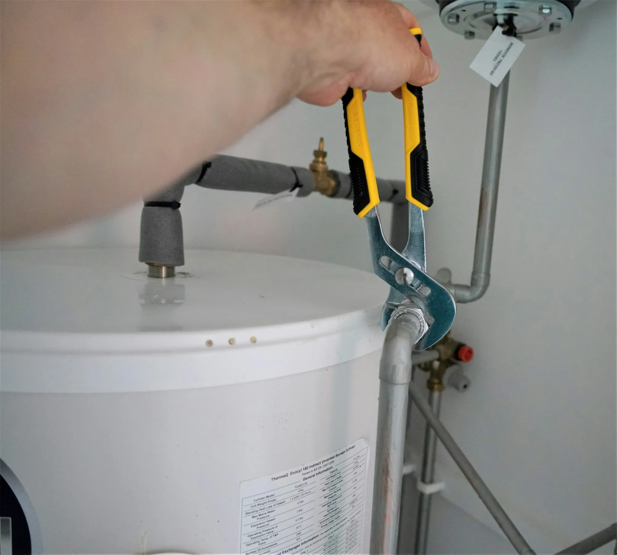 Technician fitting a water line with pliers